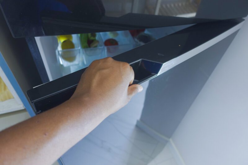 Šiuolaikinis šaldytuvas virtuvėje su užrašais ant durų